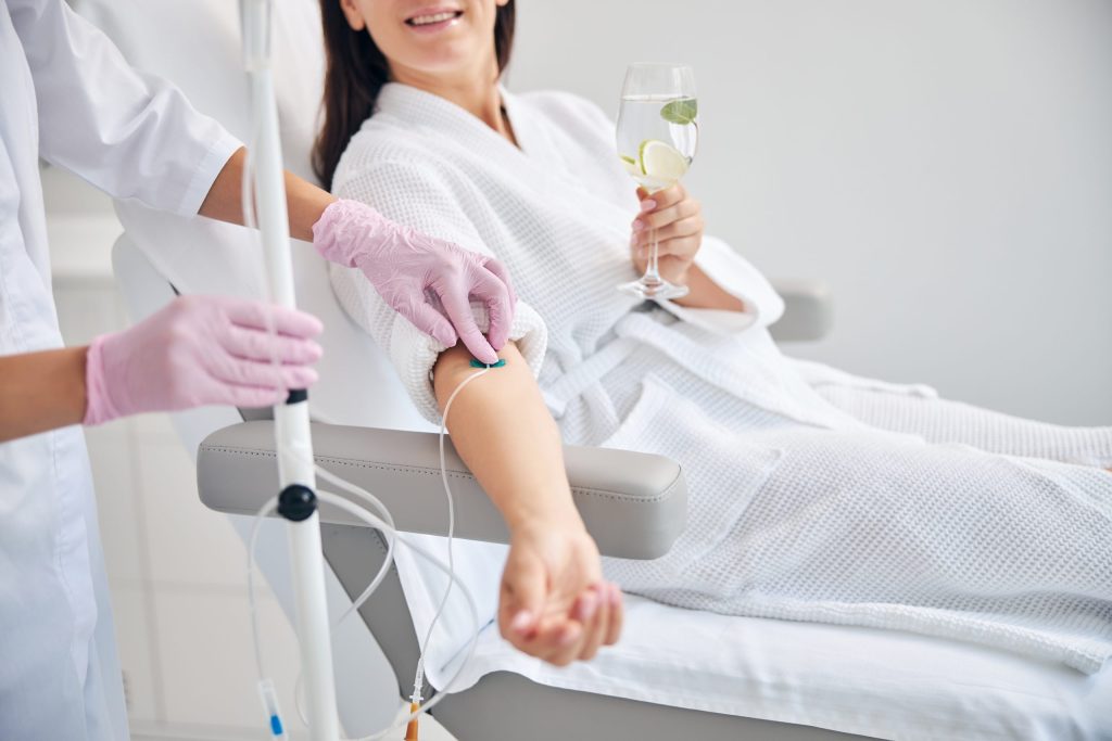 Smiling female patient undergoing intravenous vitamin therapy