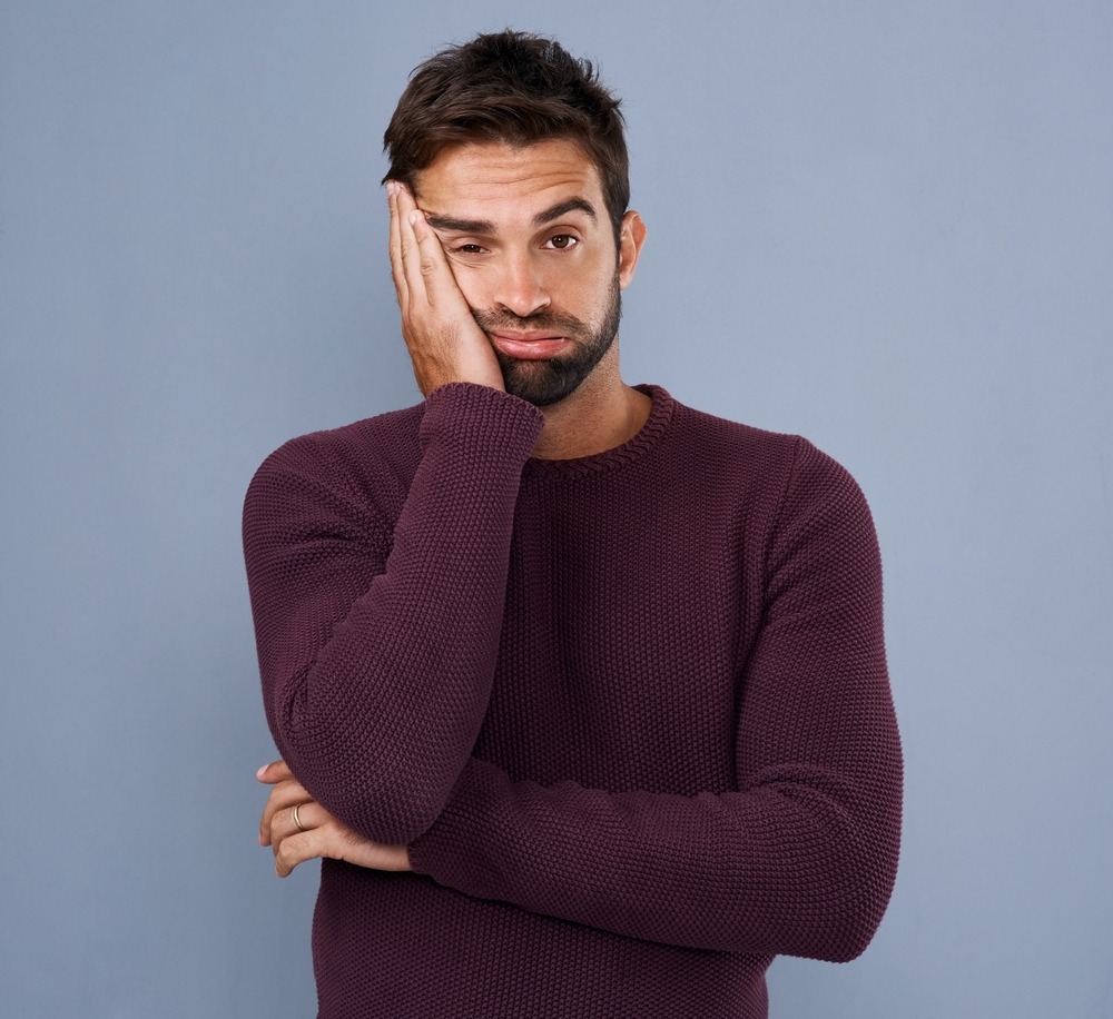 Studio, fatigue and portrait of man, sad and stress for burnout, mental health and tired with depression. Blue background, face and anxiety of person, unhappy