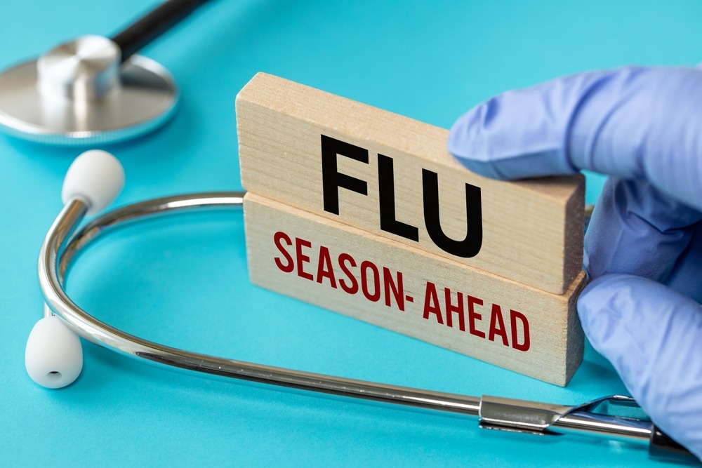 Flu Season ahead symbol. Flu Season ahead concept word on wooden blocks. Doctor's hand. Blue background and stethoscope. Medicine and Flu